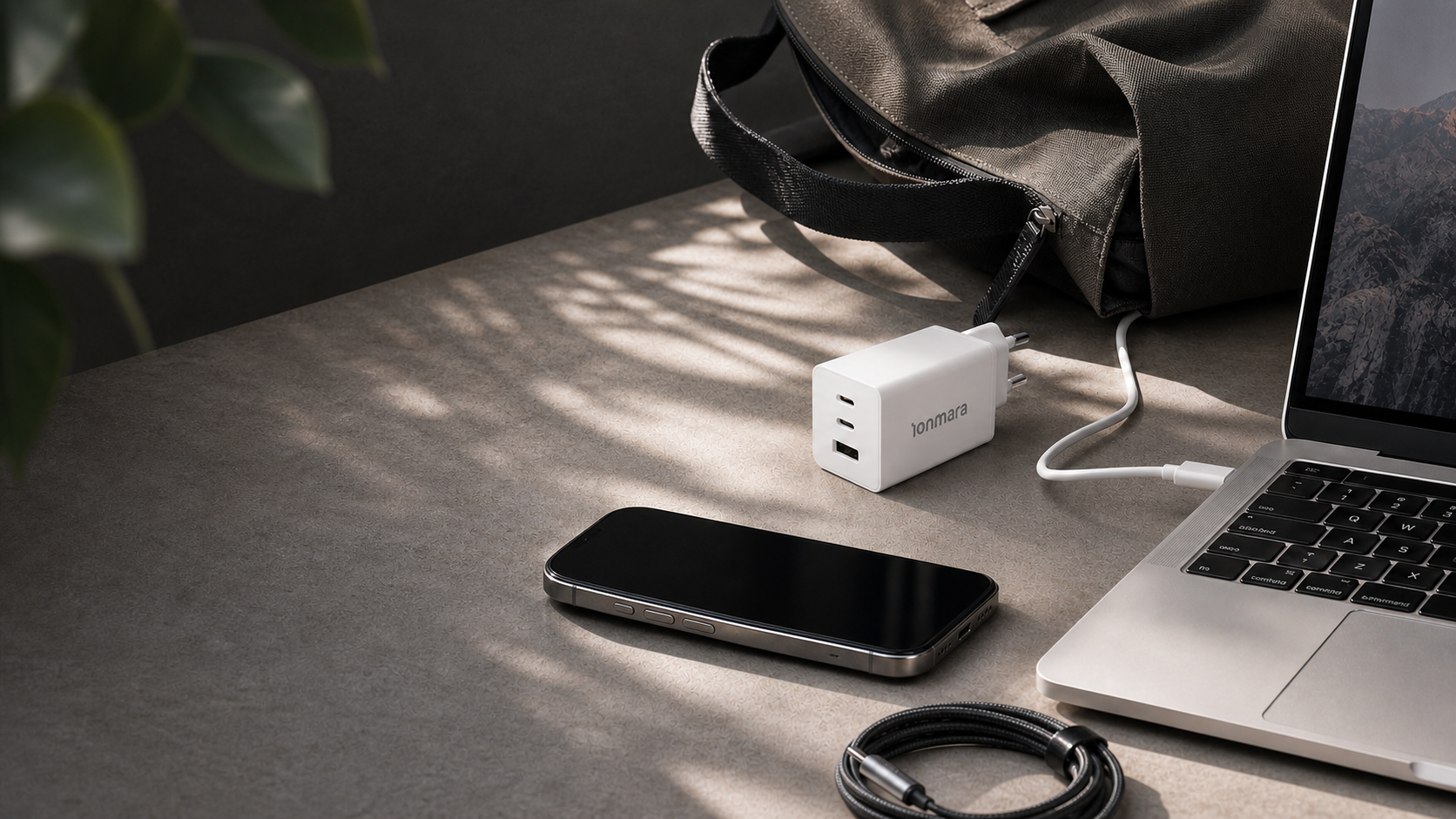 Ionmara charger, laptop, phone, and travel bag on a work desk